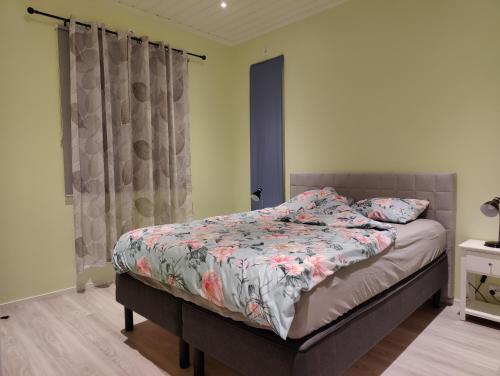 een slaapkamer met een bed met een bloemdekbed bij ANDY - Perfect location in the heart of Närpes 75 m2 - Sauna and AC - Built in 2023 in Närpiö