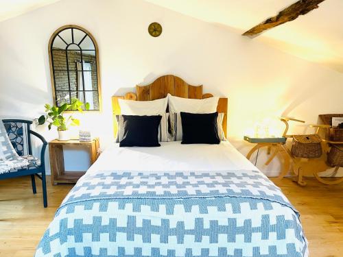 um quarto com uma cama grande com cabeceira de madeira em Villa Toscane créations à 20 mn de Toulouse em Azas