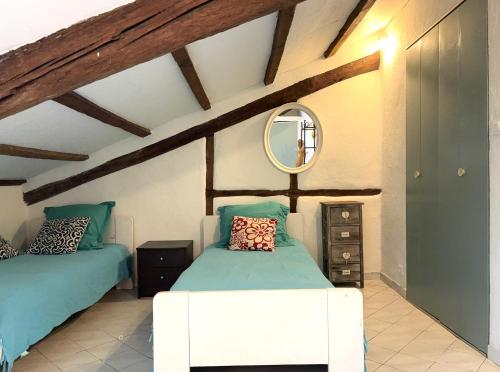 une chambre avec deux lits et un miroir dans l'établissement Garibaldi mansardé, à Nice