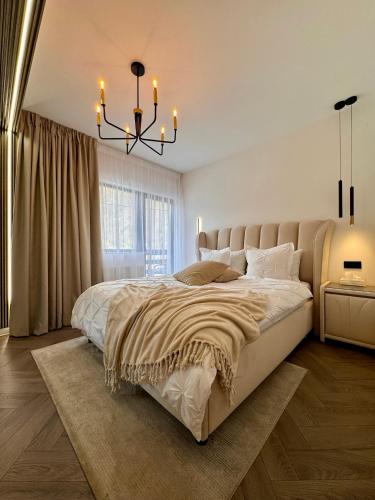 a bedroom with a large bed and a chandelier at Greg Rooms in Sinaia
