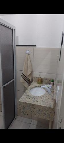 a bathroom with a sink and a towel on a counter at Casa da Lu in Aparecida