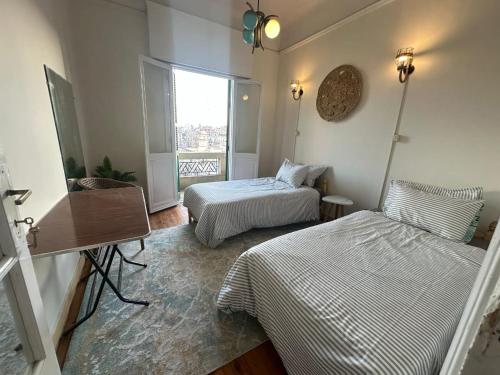 a small room with two beds and a window at Agora House for men only 仅限男性 in Alexandria