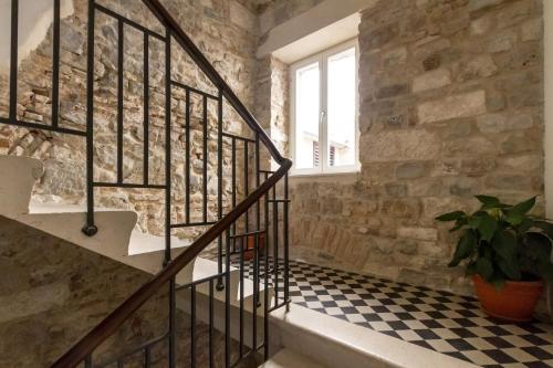 una escalera en un edificio de piedra con suelo ajedrezado en Penthouse Matkovic, en Split