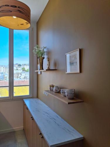 une cuisine avec un comptoir bleu et une fenêtre dans l'établissement Séjour chic en Art Déco, à Granville