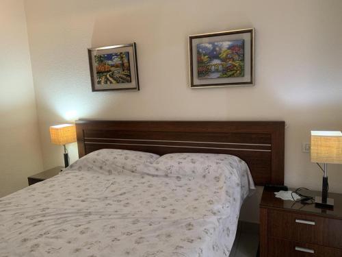 a bedroom with a bed and two pictures on the wall at Primavera Deluxe in Costa Del Silencio