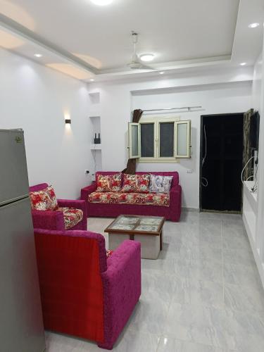 a living room with purple couches and a table at Guest house science W 1 in Marsa Alam City