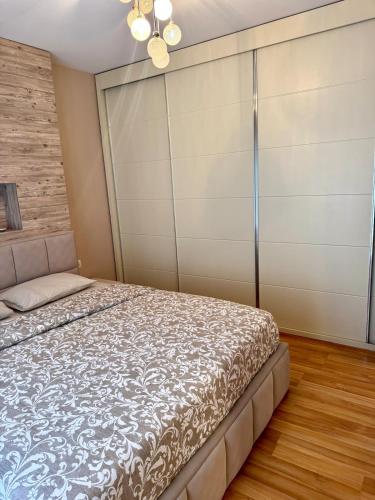 a bedroom with a bed and a closet at Tirana Lake Spacious Apartment in Sauk