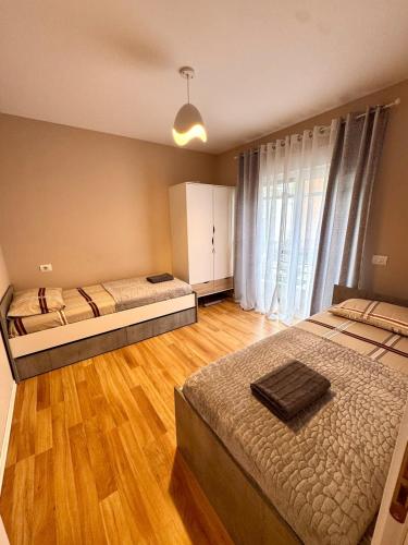 a bedroom with two beds and a wooden floor at Tirana Lake Spacious Apartment in Sauk