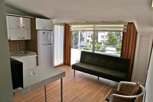 a living room with a couch and a kitchen at Erol Apart in Kemer