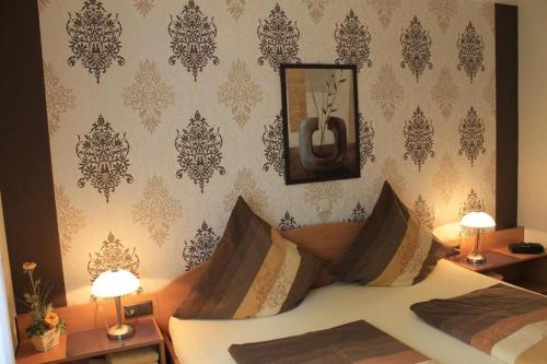 a bedroom with a bed with a mirror and two lamps at Ferienwohnungen am Dreiländersee - zertifiziert - Annemarie Mantke in Haltepunkt Driland