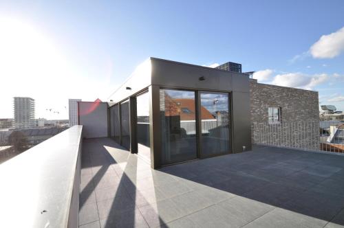 a building with large glass doors on a roof at Cadix 35 in Antwerp