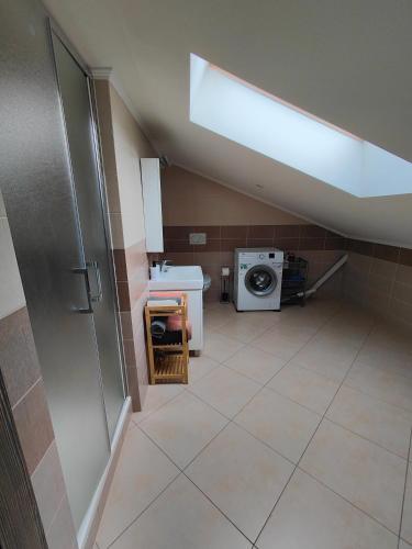 a bathroom with a sink and a washing machine at Villa Pirken Hammer in Pirkenhammer