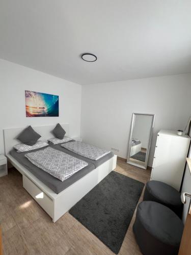 a bedroom with a bed and a chair and a mirror at Ferienwohnung Alte Brauerei in Leipzig