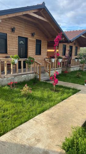 a house with a porch with flowers in the yard at Guest House Dimal Berat in Pashalli