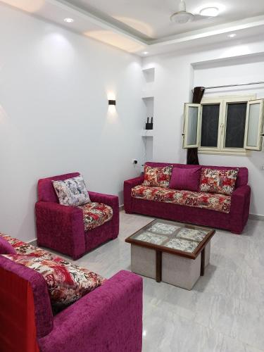 a living room with two couches and a coffee table at Guest house science W 1 in Marsa Alam City