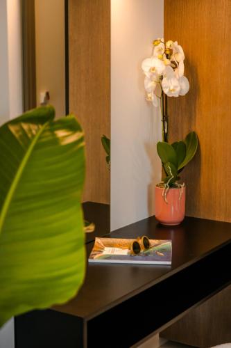 a table with a plate of food and a vase with flowers at X luxury suites in Argostoli