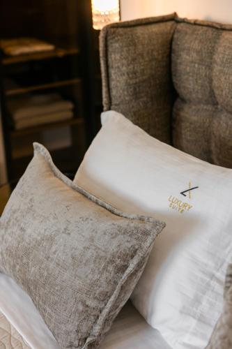 a pillow with a cross on it sitting on a bed at X luxury suites in Argostoli