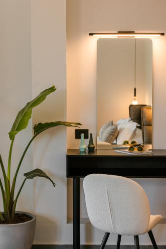 a bedroom with a desk and a chair and a mirror at X luxury suites in Argostoli