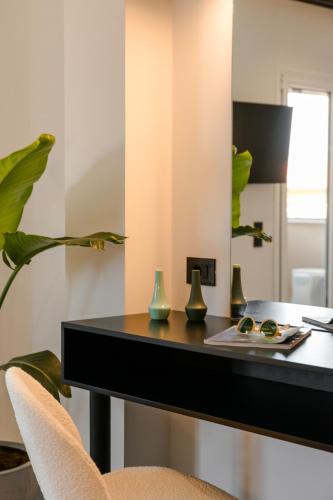 a black desk with vases and a mirror at X luxury suites in Argostoli