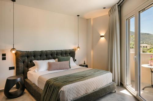 a bedroom with a large bed and a balcony at X luxury suites in Argostoli