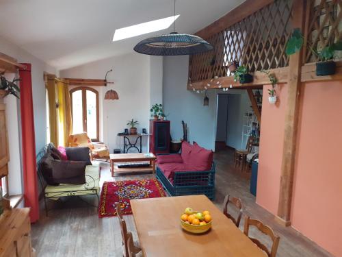 un salon avec une table avec un bol de fruits dessus dans l'établissement Gîte à la ferme, à Montolieu