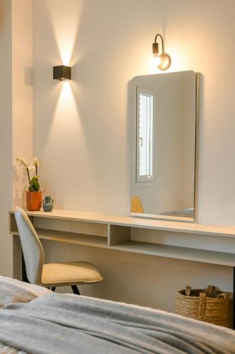 a bedroom with a mirror and a chair next to a bed at X luxury suites in Argostoli