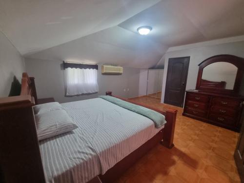a bedroom with a bed and a dresser in it at El Eden de la Familia in Choluteca