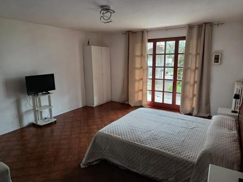a bedroom with a bed and a tv and a window at Casa Eben-Haezer in Fiumana