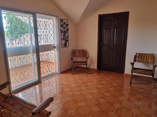 an empty room with a door and two chairs at El Eden de la Familia in Choluteca