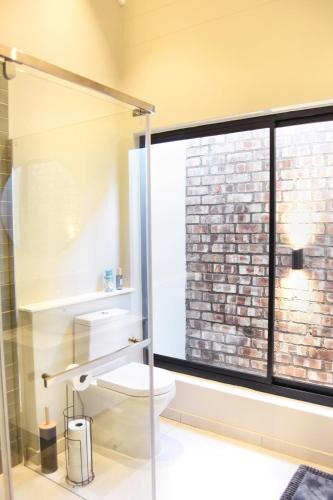 a bathroom with a toilet and a large window at Rustic Hills #7 Self-catering in Swakopmund