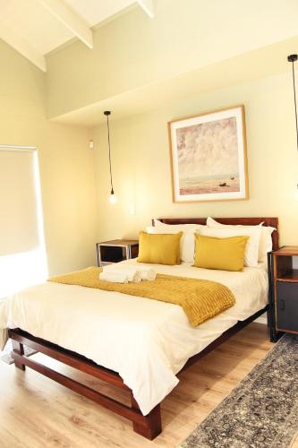 a bedroom with a large bed with yellow pillows at Rustic Hills #7 Self-catering in Swakopmund