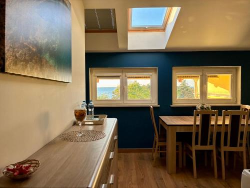 a kitchen with a table and chairs and windows at Rezydencja Sara in Międzyzdroje