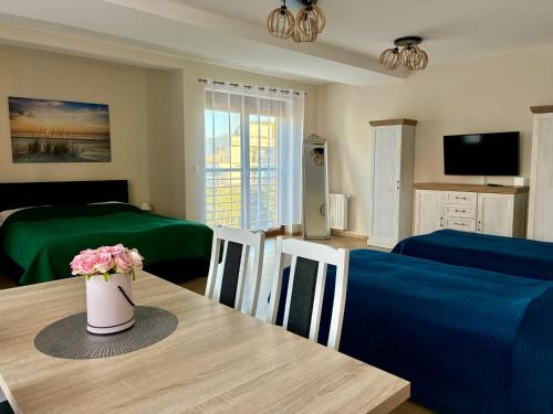 a living room with a table with a vase of flowers on it at Rezydencja Sara in Międzyzdroje