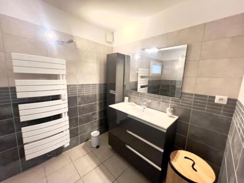 a bathroom with a sink and a mirror at Villa Léa Alès 5 chambres in Alès