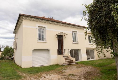 a white house with a gate and a garage at Villa Léa Alès 5 chambres in Alès