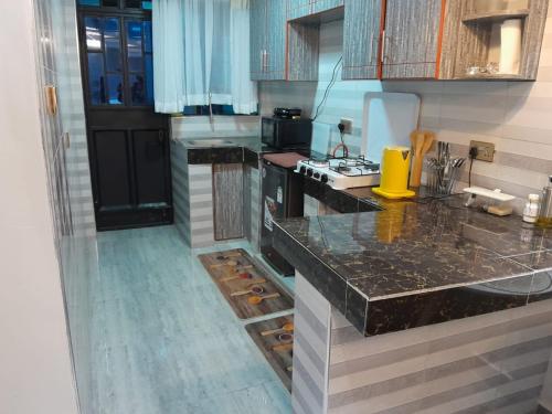 a kitchen with black counter tops and a counter top at Staycation by Winnie-Weber Generations -2 bedrooms in Nairobi