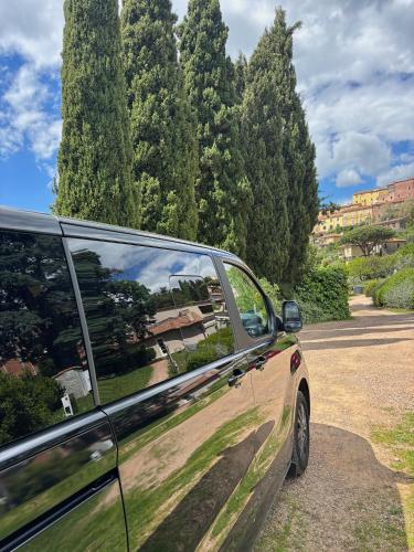 a car parked in a parking lot with trees at Relais dei Molini - Villa dei Molini in Castagneto Carducci