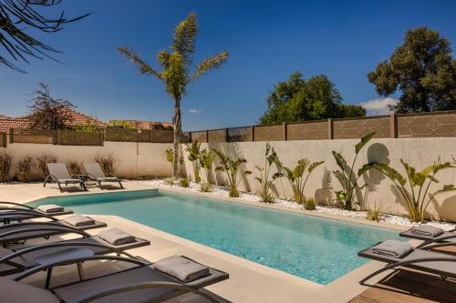 a swimming pool with lounge chairs next to a fence at X luxury suites in Argostoli