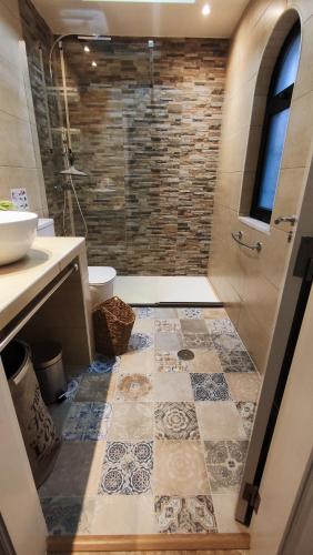a bathroom with a shower and a tiled floor at B&B Chambre 1 Vila Alegria ESTOI in Estói