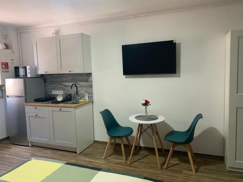 a kitchen with a table and two chairs and a counter at DBO Kaufland-Vivo in Baia Mare
