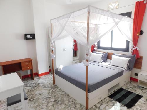 a bedroom with a bed with a canopy at PROMO!! 20euros le T2 à 30euros lr T3 pour les mois de sept Oct et Novembre Centre-Ville DIEGO-SUAREZ au nord de MADAGASCAR in Diego Suarez