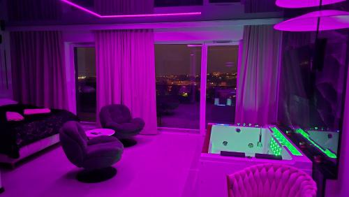a room with pink lighting and a video game at Apartament dla dwojga z jacuzzi na wyłączność in Świecie
