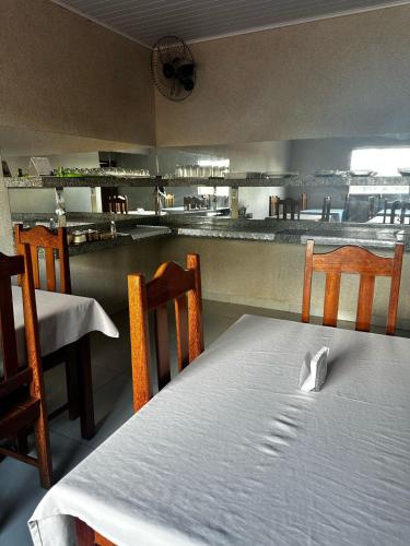 a room with a table and chairs and a kitchen at Hotel Carajás II in Canaã dos Carajás