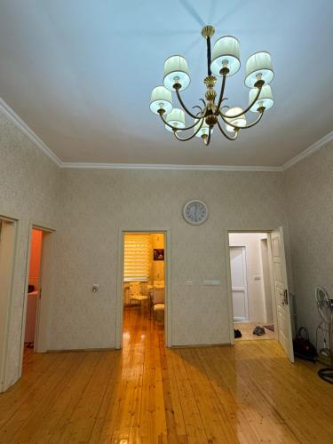 a living room with a chandelier and a dining room at Villa Botanica Lankaran in Lankaran