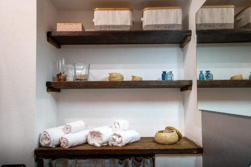 un estante con toallas y otros artículos. en Fonterutoli Apartment, en Fonterutoli