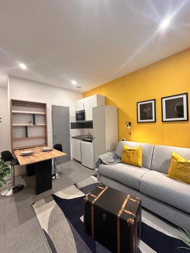 un salon avec un canapé et une table dans l'établissement Le coeur Jaune de Mulhouse, à Mulhouse