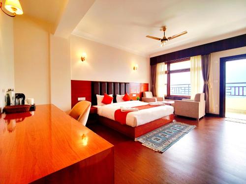 a hotel room with a bed and a desk and a table at Jo'stel Heritage - Tadong Tashi Hotel and Spa - Near MG Marg - 4 Star Hotel in Gangtok