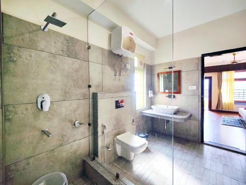 a bathroom with a toilet and a glass shower at Jo'stel Heritage - Tadong Tashi Hotel and Spa - Near MG Marg - 4 Star Hotel in Gangtok