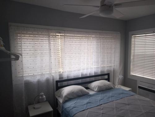 a bedroom with a bed with two pillows and a window at Tropical Sky Ranch Motel in Clearwater Beach