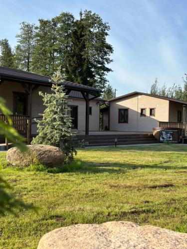a house with a pine tree in the yard at Villa Vlada in Gāršmuiža